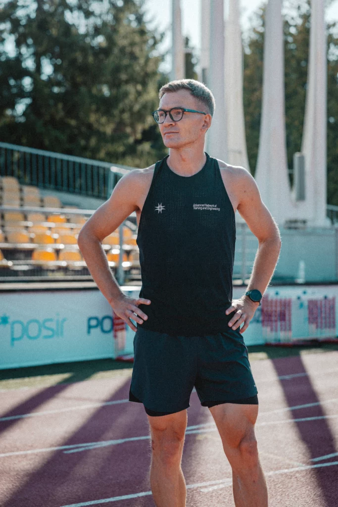 Piotr Tomczyk, trener biegania, stoi na stadionie lekkoatletycznym w Poznaniu.