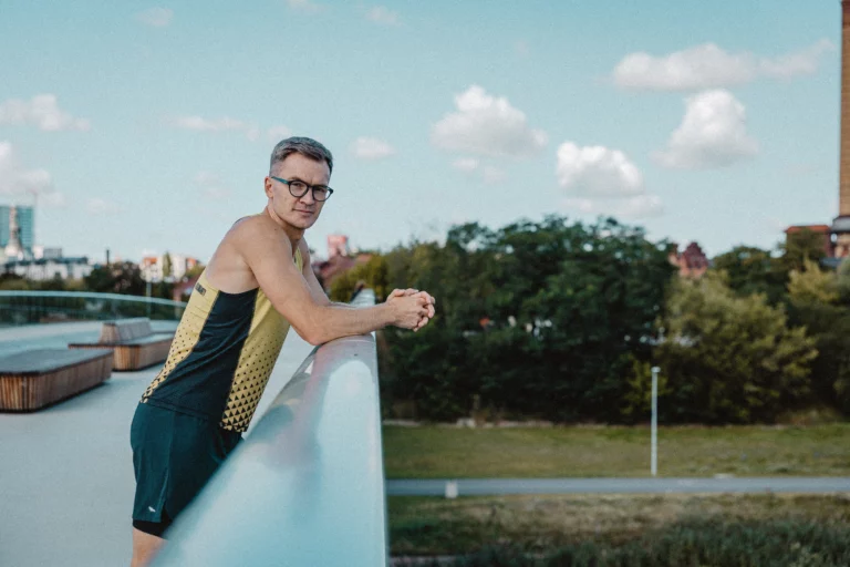 Piotr Tomczyk stoi na moście w Poznaniu